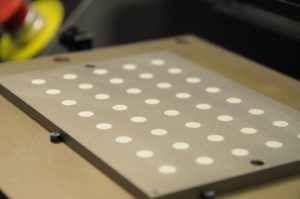 Typical fixture plate for automatic screen printing of electrodes on PZT disk substrates.