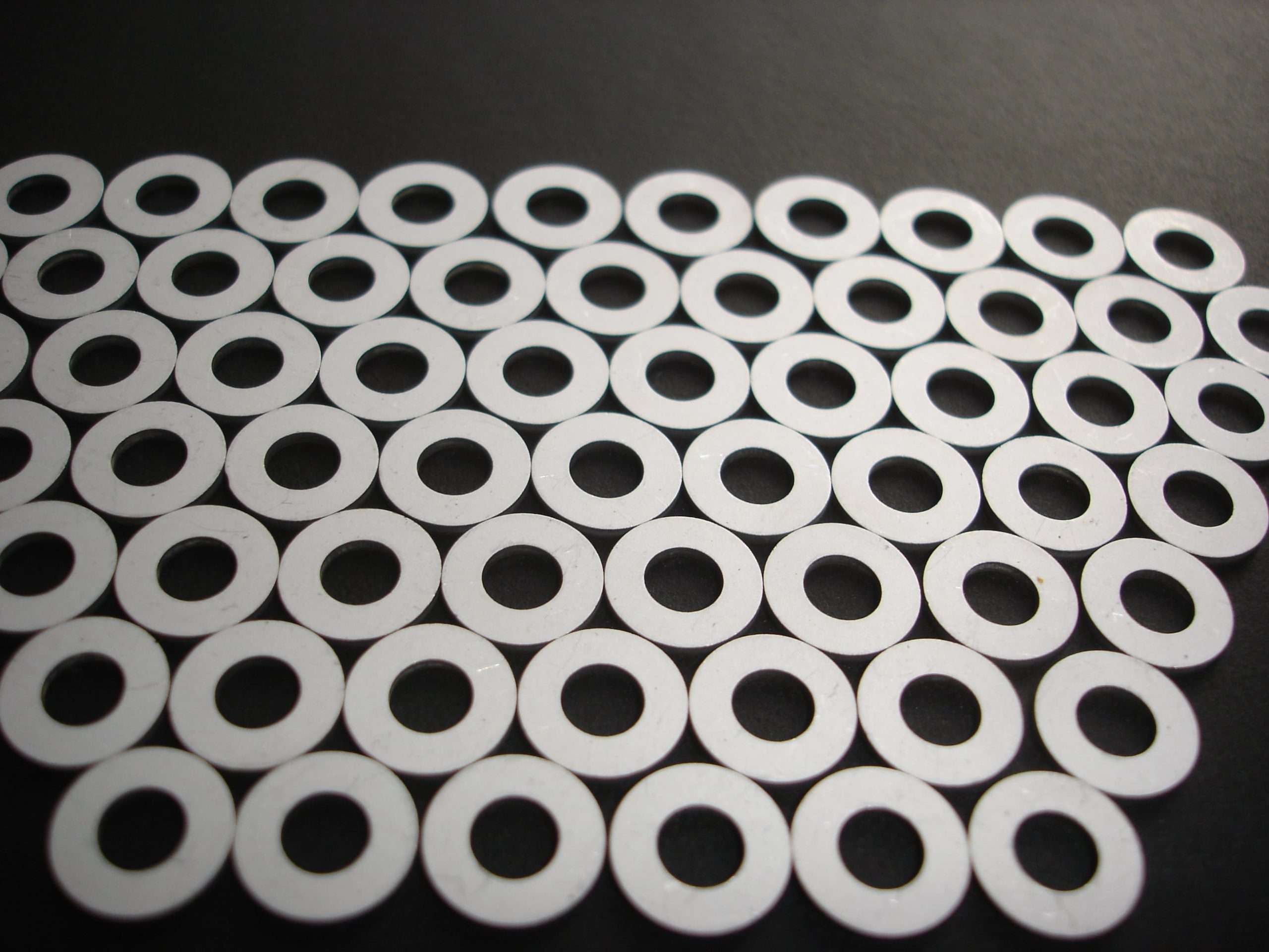 a bunch of white circles with holes in them