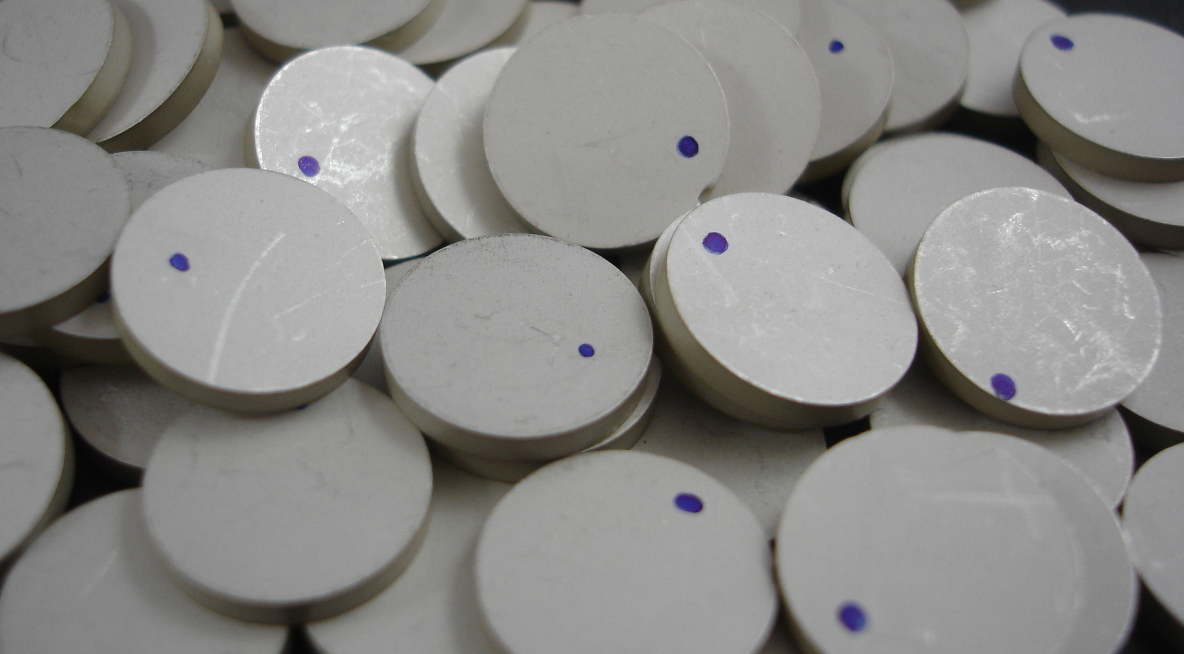 a pile of white circles with purple dots on them