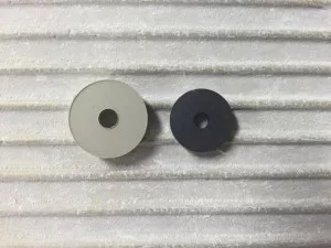 two circles with holes in them are sitting on a white surface .