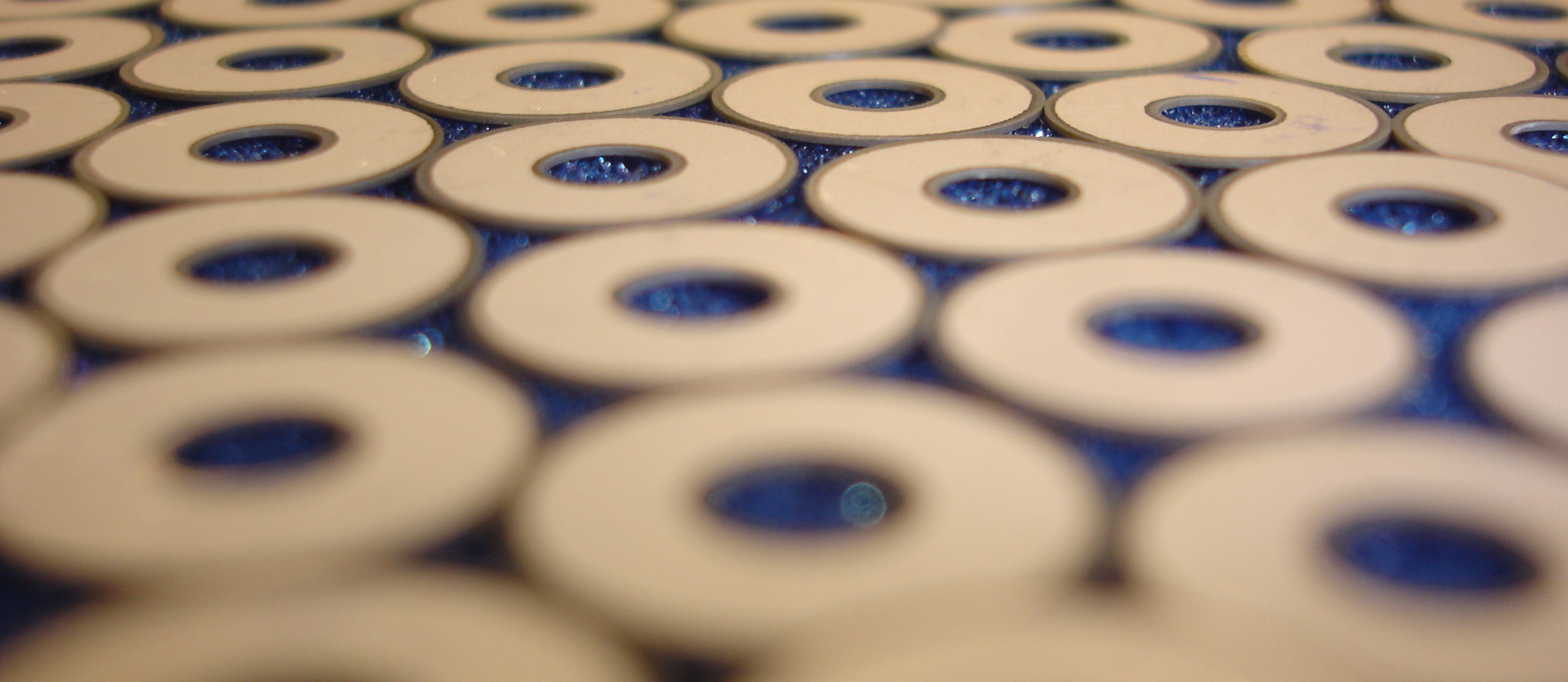 a bunch of circles with holes in them on a blue surface